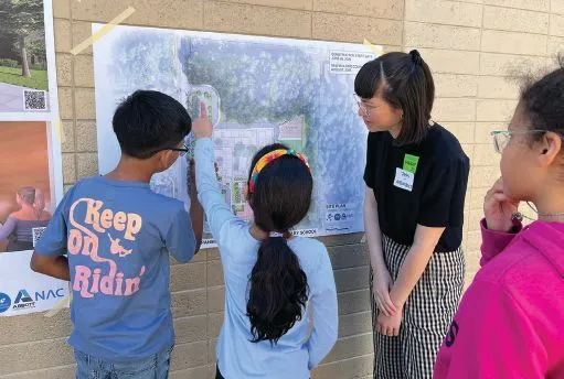 Crystal Springs Elementary Expansion Building: NAC designer Jess Tse engages with students at recess as they review the new site plan of their school in the Northshore School District. Photo: Cheryl Jacobs